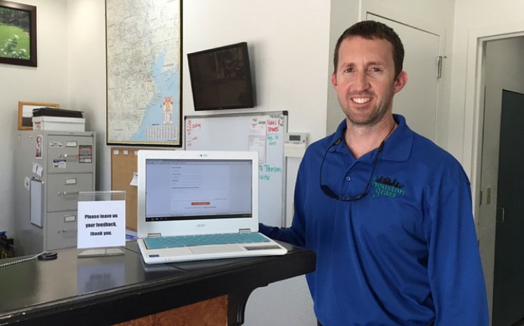 Michael Romine, owner of Houston Grass South, asks customers to leave feedback with a Chromebook.