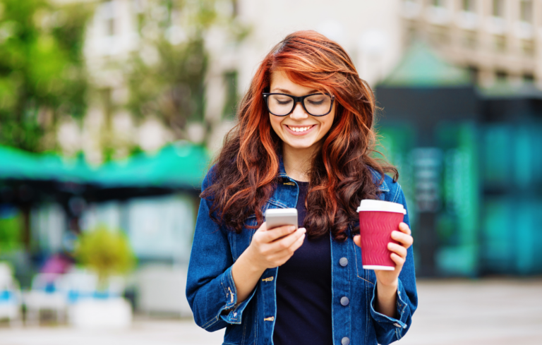 Women getting sms campaign text on her phone while enjoying coffee