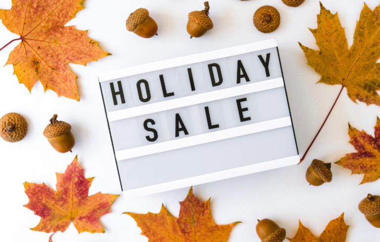 picture that says holiday sale on a sign with some leaves and acorns around it