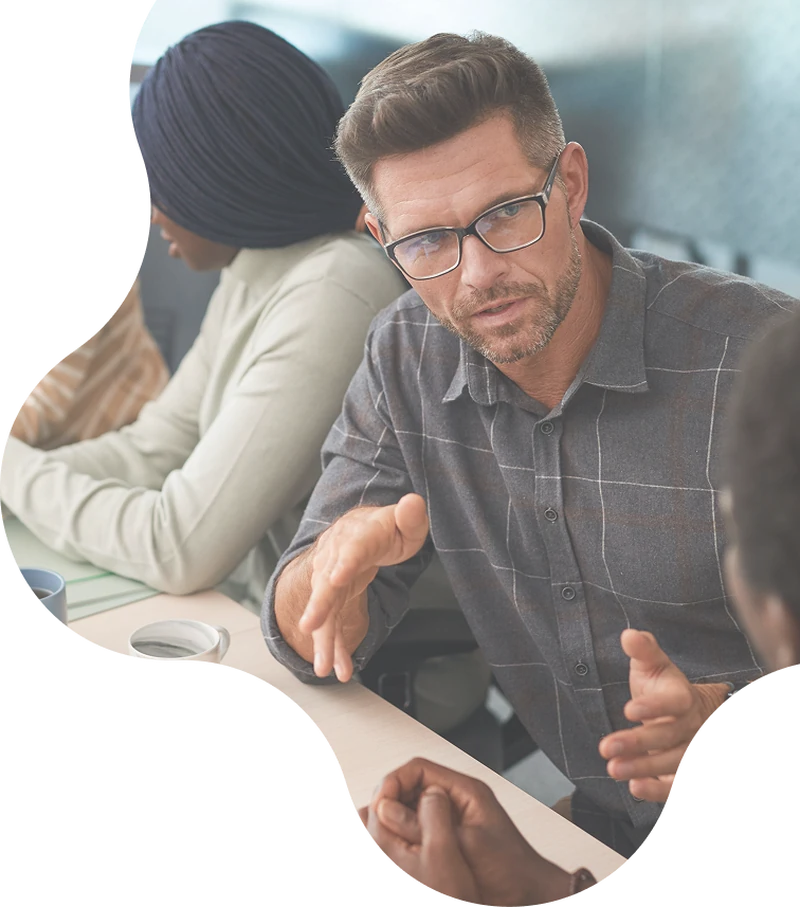 An agency team talking with a client across a table.